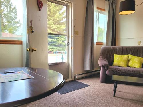 a living room with a table and a couch at Lido Motel in Radium Hot Springs