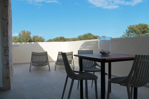 een patio met een tafel en stoelen op een balkon bij Serena Sol in Cala Serena