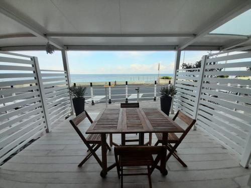 - une table et des chaises sur une terrasse avec vue sur la plage dans l'établissement La casa di SELLY 2 - A Due Metri Dal Mare-, à Bergeggi