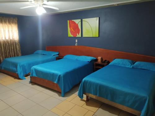 - 2 lits dans une chambre aux murs bleus dans l'établissement Hotel POSADA DEL REY, à Matamoros