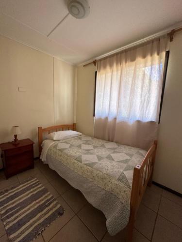 a bedroom with a bed and a window at Cabañas Florencia La Serena in La Serena
