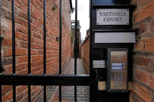 a pay phone on the side of a brick building at Crewe Short Lets 6 Victoria Court, Crewe in Crewe