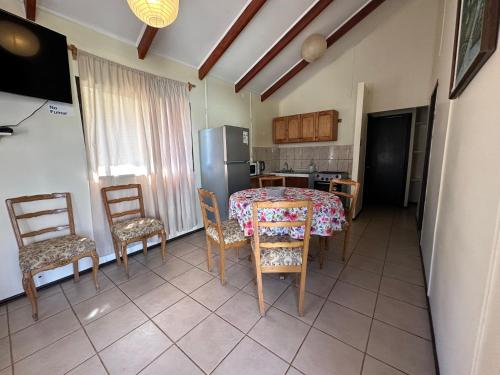 a kitchen with a table and chairs and a refrigerator at Cabañas Florencia La Serena in La Serena