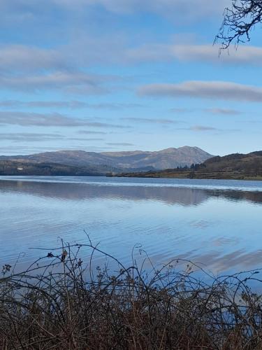 a large body of water with mountains in the background at Pinetree Cottage, dog friendly, Holiday let, Callander Invertrossachs in Callander