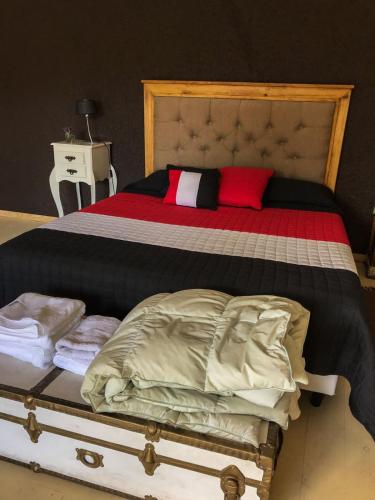 1 cama grande con edredón rojo y blanco en Departamentos El Milagro in 