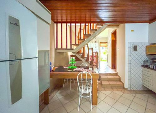 a kitchen with a wooden table and a staircase at Casa com piscina em Riviera de Sao Lourenco SP in Riviera de São Lourenço