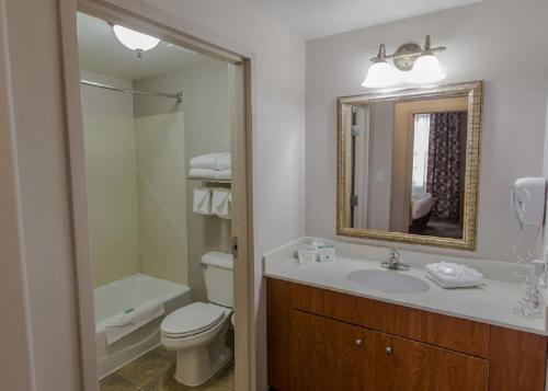a bathroom with a sink and a toilet and a mirror at MainStay Suites Casper in Casper