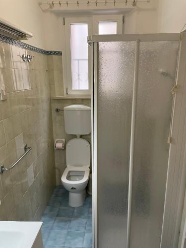 a bathroom with a toilet and a glass shower door at Le Civette in Ferrara