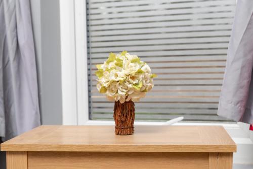 een vaas met bloemen bovenop een tafel bij Harewood Lodge Darlington Luxury Apartments in Darlington