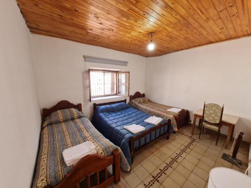 1 dormitorio con 2 camas, mesa y ventana en Mis Marias en Villa Unión