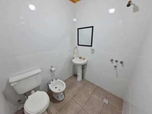 een witte badkamer met een toilet en een wastafel bij Mis Marias in Villa Unión
