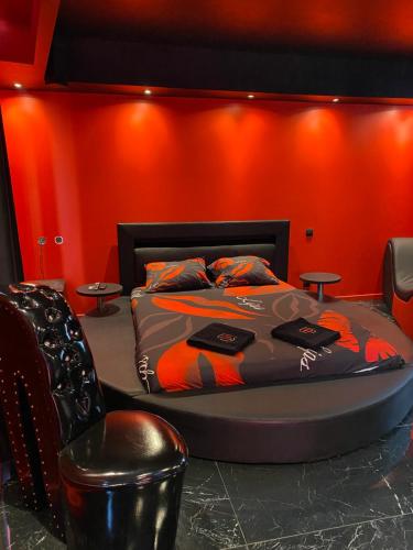 une chambre avec un lit et un mur rouge dans l'établissement Le souffle de l’amour, à Melun
