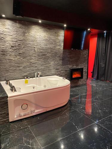 a bath tub in a room with a fireplace at Le souffle de l’amour in Melun