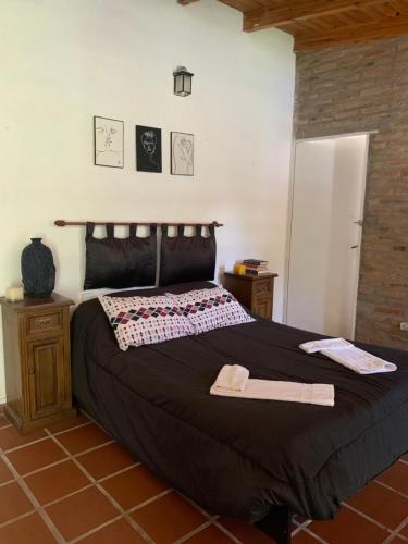 1 dormitorio con 1 cama grande y edredón negro en Aires Verdes en Río Ceballos