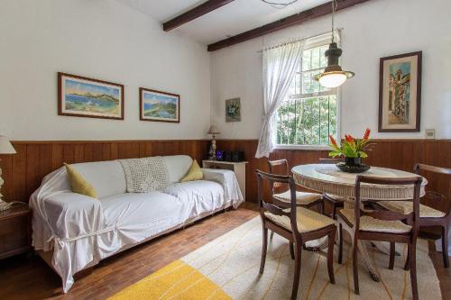 een woonkamer met een bank en een tafel bij Refugio Na Serra, 5Qts Vista Mata Atlantica in Teresópolis