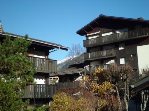 un groupe de bâtiments avec balcon et arbres dans l'établissement Charmant appartement à Chamonix avec balcon, animaux admis, parking - FR-1-517-12, à Chamonix-Mont-Blanc
