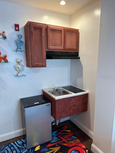 una cocina con fregadero y armarios de madera en Art Deco Graffiti Suite en Filadelfia