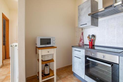 eine Küche mit einer Spüle und einer Mikrowelle in der Unterkunft Pretty house in Viareggio