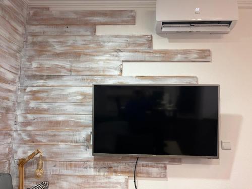 a flat screen tv hanging on a wall at Cantinho da Aldeia in Tomar