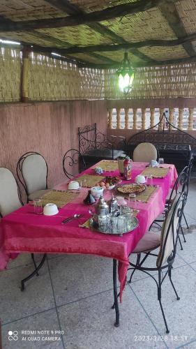 una mesa con un mantel rosa. en Afgo Hostel, en Ouarzazate