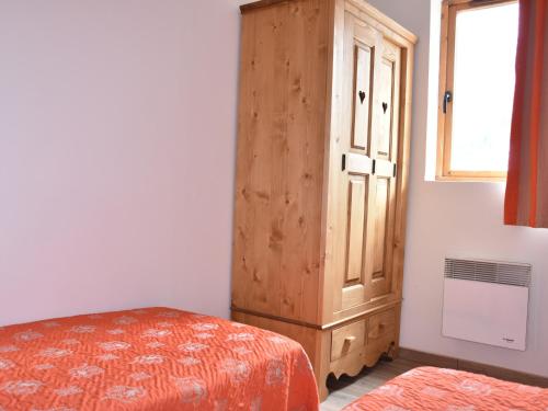 een slaapkamer met een houten kast naast een bed bij Appartement cosy proche commerces, animaux bienvenus, parking - FR-1-464-160 in Pralognan-la-Vanoise