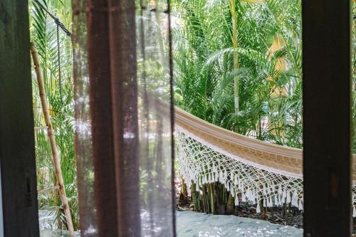 a hammock in a tropical garden seen through a window at Lua Villas in Santa Teresa Beach