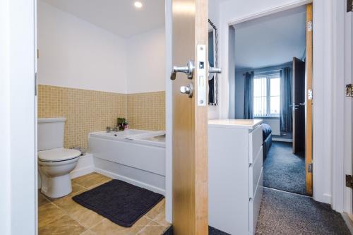a bathroom with a tub and a toilet and a sink at MODERN 2 BEDROOM 2 BATHROOM APARTMENT SLEEPS 4 IN WARRINGTON FOR WORK AND LEISURE WITH PRIVATE PARKING BY AMAZING SPACES RELOCATIONS Ltd in Warrington