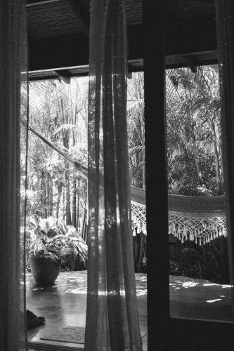a black and white photo of a window with plants at Lua Villas in Santa Teresa Beach