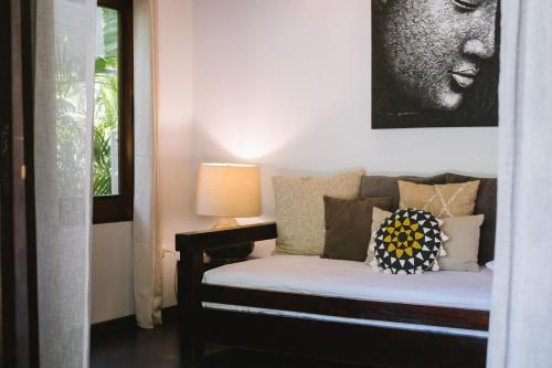 a room with a bed with a picture on the wall at Lua Villas in Santa Teresa Beach