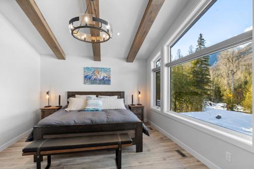 1 dormitorio con cama y ventana grande en Falling Star Ski House en Fernie