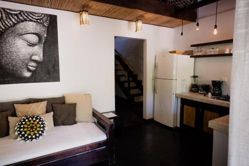 a living room with a couch and a painting on the wall at Lua Villas in Santa Teresa Beach