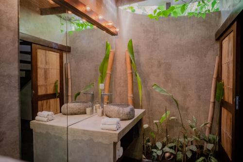 a bathroom with two sinks and plants at Lua Villas in Santa Teresa Beach