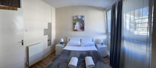 a small bedroom with a bed and a window at 2-bedroom Flat in Regents Park-Euston-Camden in London