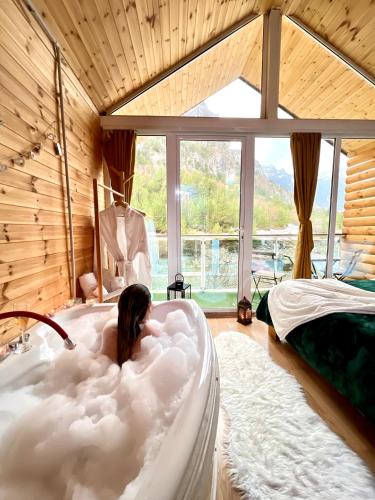 a woman laying in a cloud shaped bath tub at Guesthouse Marashi in Theth