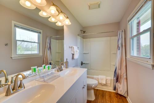 La salle de bains est pourvue de 2 lavabos, de toilettes et d'une fenêtre. dans l'établissement Home Rental with Yard Near Downtown Greensboro!, à Greensboro