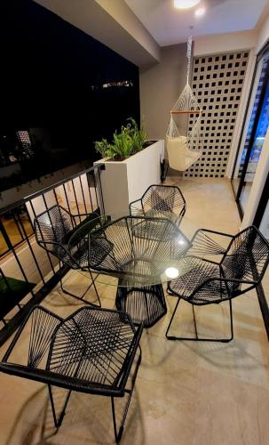 a balcony with chairs and a table and a swing at IYARI 2 bdr Apartment in Nuevo Vallarta