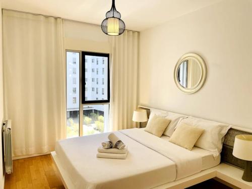 een slaapkamer met een groot wit bed en een raam bij Airport Expo Apartment in Lissabon