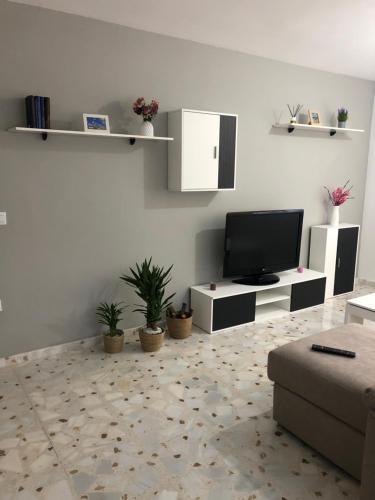 ein Wohnzimmer mit Fernseher und Sofa in der Unterkunft Casa turismo rural Becar in Corullón