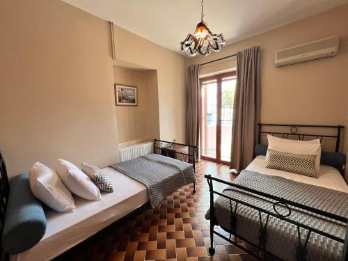 sypialnia z 2 łóżkami i żyrandolem w obiekcie Antonios House Ithaka w mieście Vathi