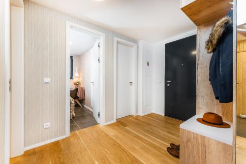 a hallway with white walls and wooden flooring in a apartment at Apartament A121 Molo Lipno s infrasaunou - Residence Koubek in Lipno nad Vltavou
