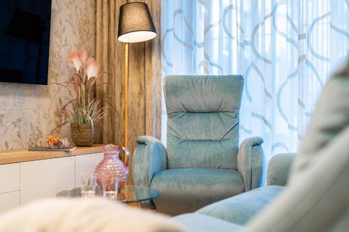 a living room with a chair and a table at Apartament A121 Molo Lipno s infrasaunou - Residence Koubek in Lipno nad Vltavou