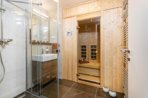 y baño con ducha y lavamanos. en Apartament A121 Molo Lipno s infrasaunou - Residence Koubek, en Lipno nad Vltavou