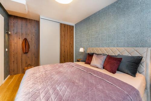 a bedroom with a large bed with pillows at Apartament A121 Molo Lipno s infrasaunou - Residence Koubek in Lipno nad Vltavou