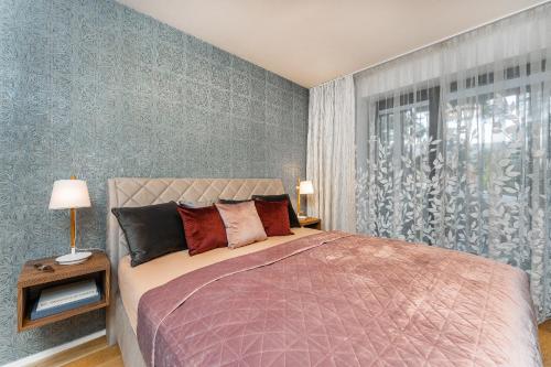sypialnia z dużym łóżkiem i oknem w obiekcie Apartament A121 Molo Lipno s infrasaunou - Residence Koubek w mieście Lipno nad Vltavou