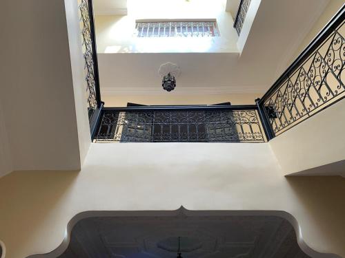 an empty hallway with a staircase with black and gold railing at Riad jmiaa in Marrakesh