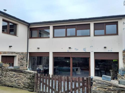 a white building with windows and a wooden fence at A casa do Val in Lugo