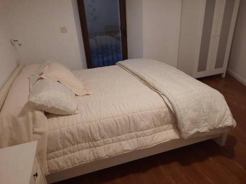 a bed with white sheets and pillows in a bedroom at A casa do Val in Lugo