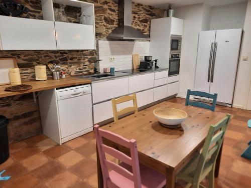 cocina con mesa de madera y sillas en A casa do Val, en Lugo