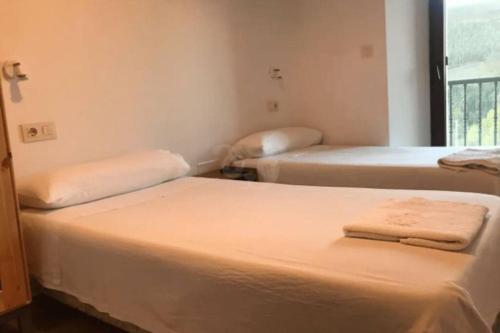 a room with two beds and a window at A casa do Val in Lugo