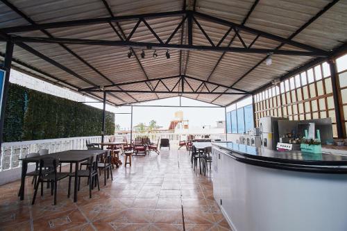 a restaurant with tables and chairs and a bar at Hostal Gardner in Puerto Ayora